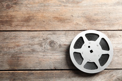 Photo of Movie reel on wooden background, top view with space for text. Cinema production