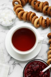 Flat lay composition with delicious ring shaped Sushki (dry bagels) and cup of tea on white marble table