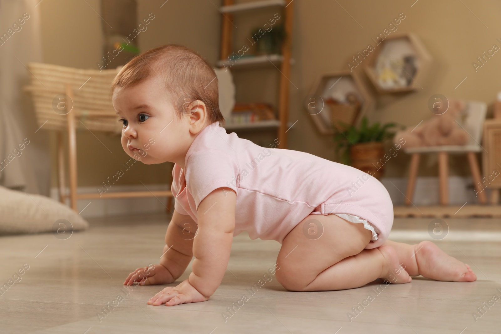 Photo of Cute baby crawling on floor at home