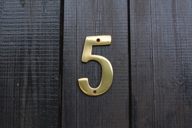 Photo of House number five on wooden door outdoors, closeup