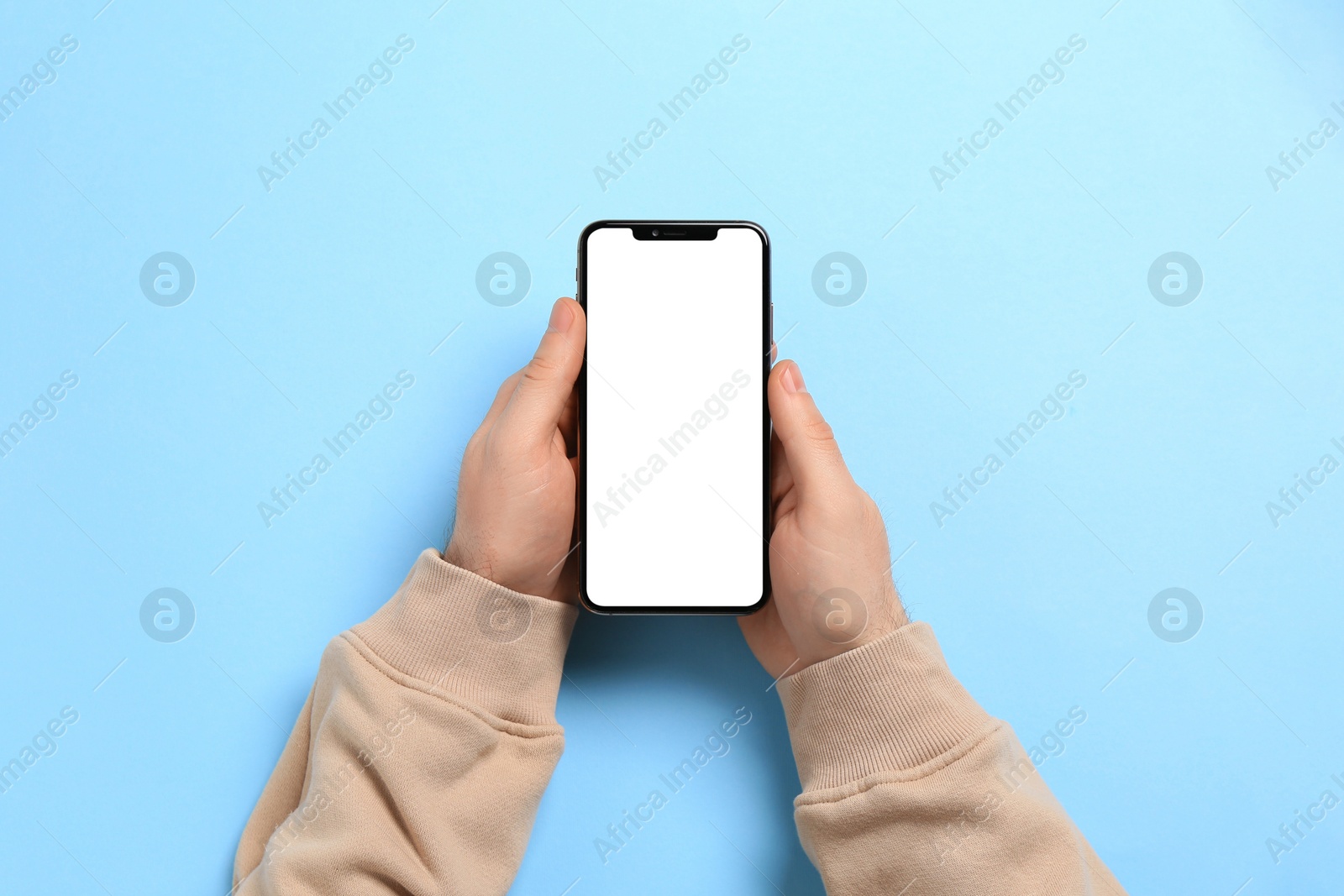 Photo of Man with smartphone on light blue background, top view