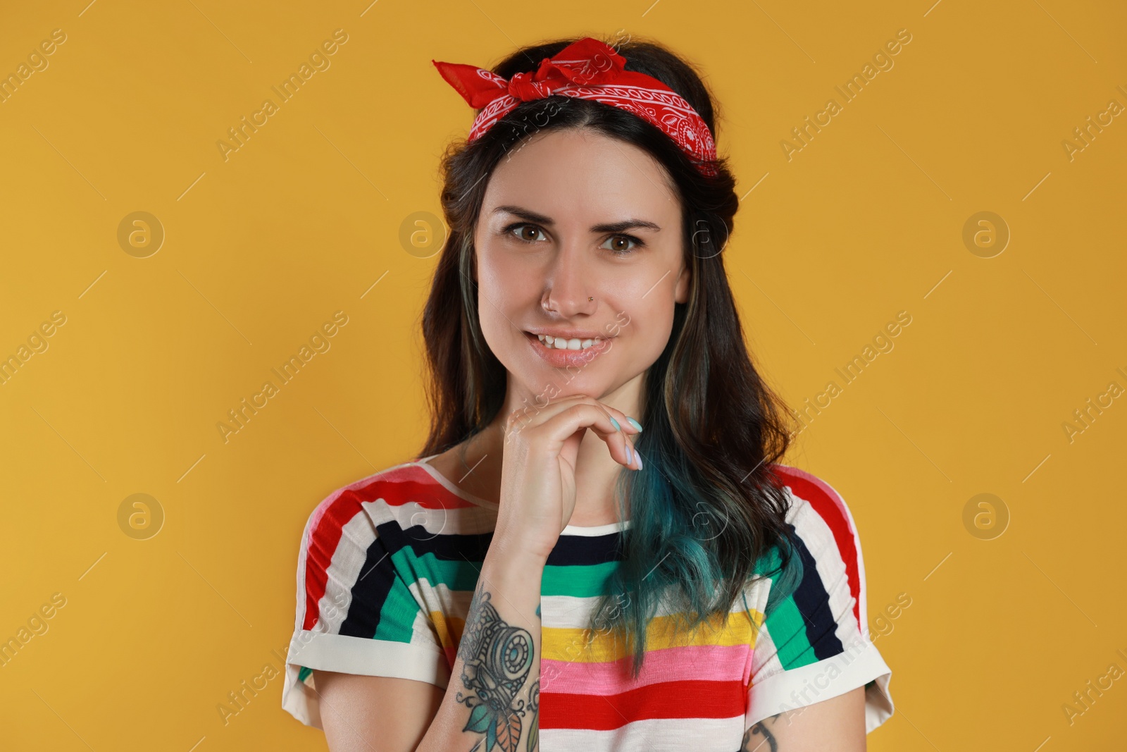 Photo of Beautiful young woman with nose piercing on yellow background