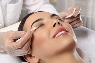 Photo of Young woman undergoing eyelash lamination in salon, closeup