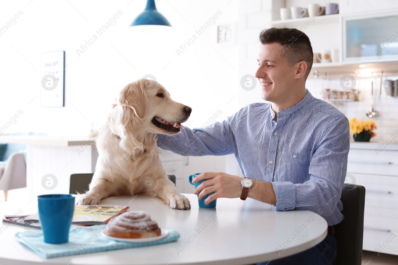 Photo of Portrait of owner with his friendly dog having breakfast at home