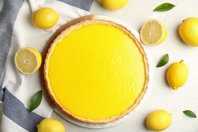 Delicious homemade lemon pie and fresh fruits on light table, flat lay