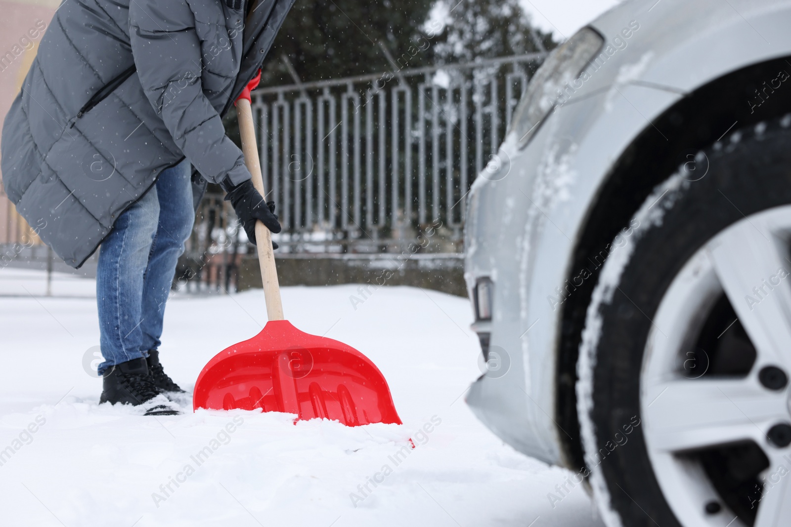 Photo of Man removing snow with shovel near car outdoors, closeup