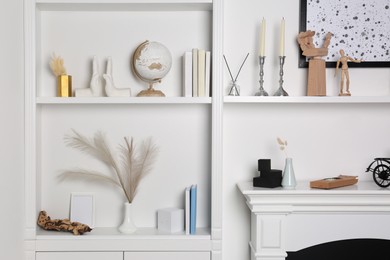 Photo of Shelving unit and fireplace with different decor indoors. Interior design