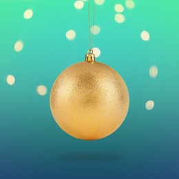 Image of Beautiful golden Christmas ball hanging on color background