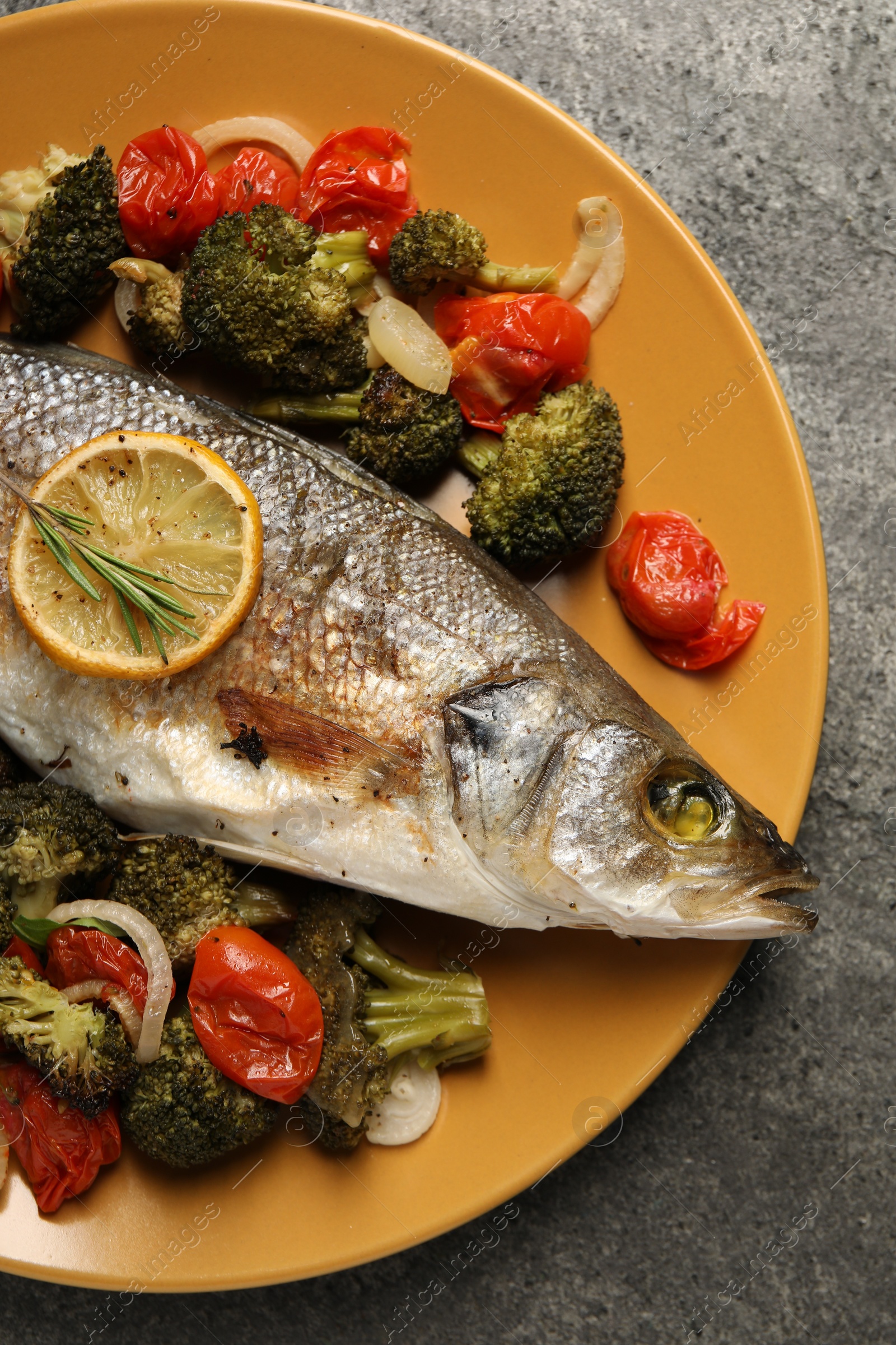 Photo of Delicious baked fish and vegetables on grey background, top view