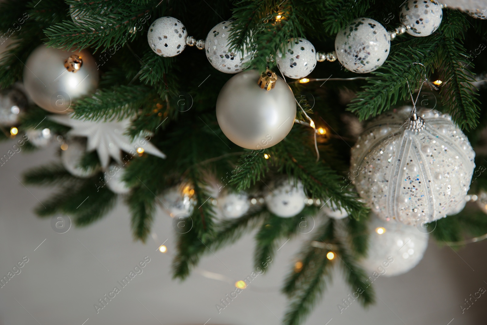 Photo of Beautiful Christmas tree decorated with festive lights and baubles indoors, closeup