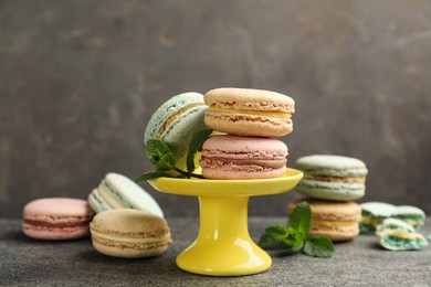 Photo of Delicious macarons on grey table. Sweet dessert