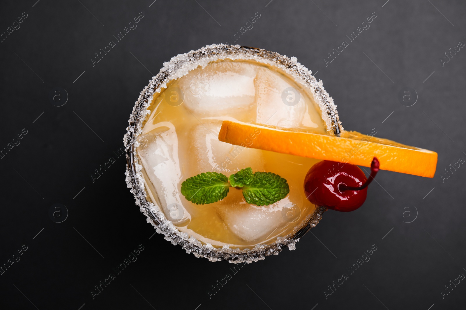 Photo of Fresh alcoholic Tequila Sunrise cocktail on black table, top view