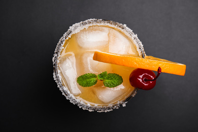 Photo of Fresh alcoholic Tequila Sunrise cocktail on black table, top view