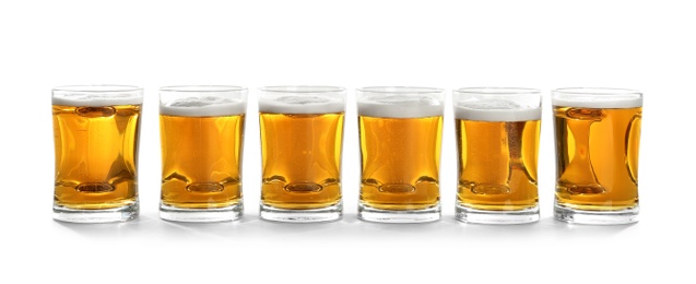 Glass mugs of beer on white background