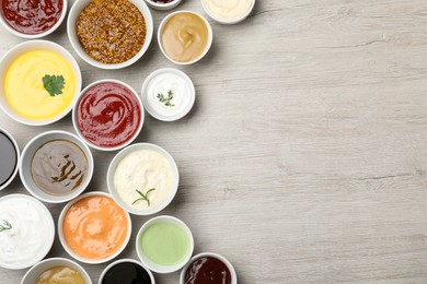 Photo of Many different sauces on white wooden table, flat lay. Space for text
