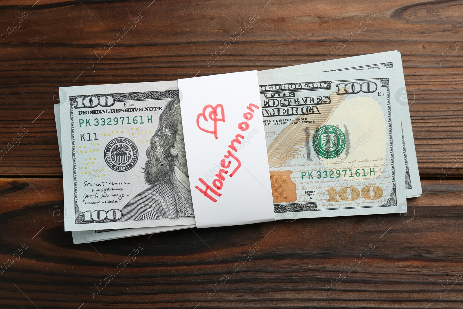 Photo of Stack of money with word Honeymoon on wooden table, top view