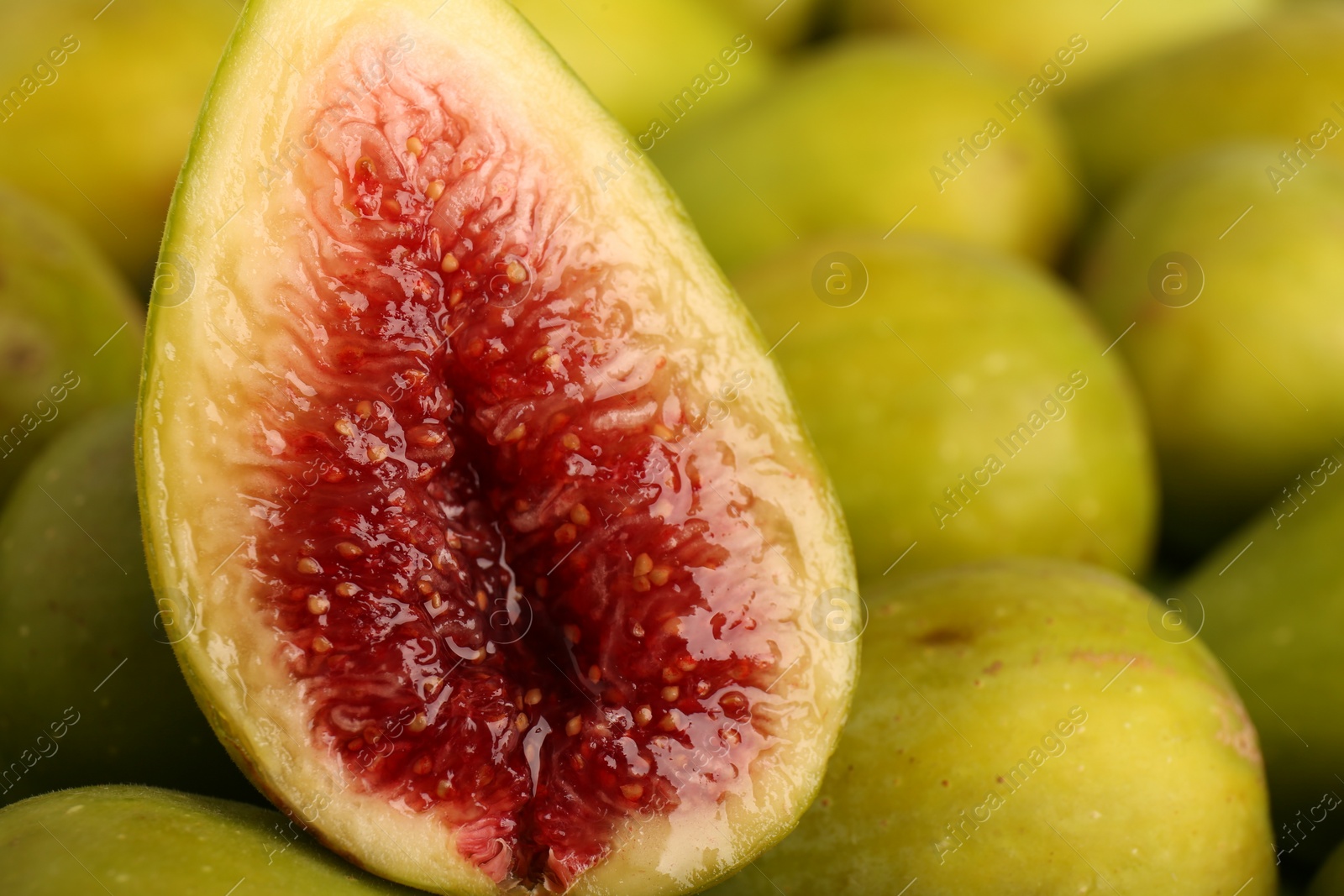 Photo of Half of green fig on fresh fruits, closeup