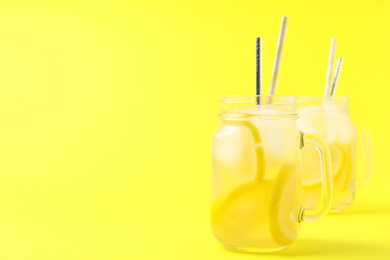 Photo of Natural lemonade on yellow background, space for text. Summer refreshing drink