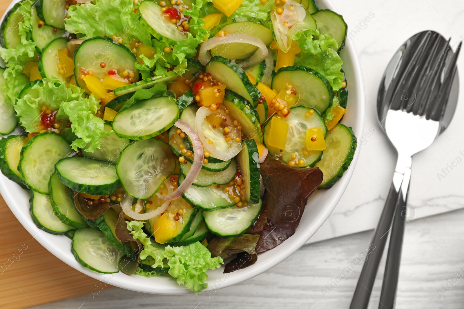 Photo of Delicious cucumber salad served on white wooden table, flat lay