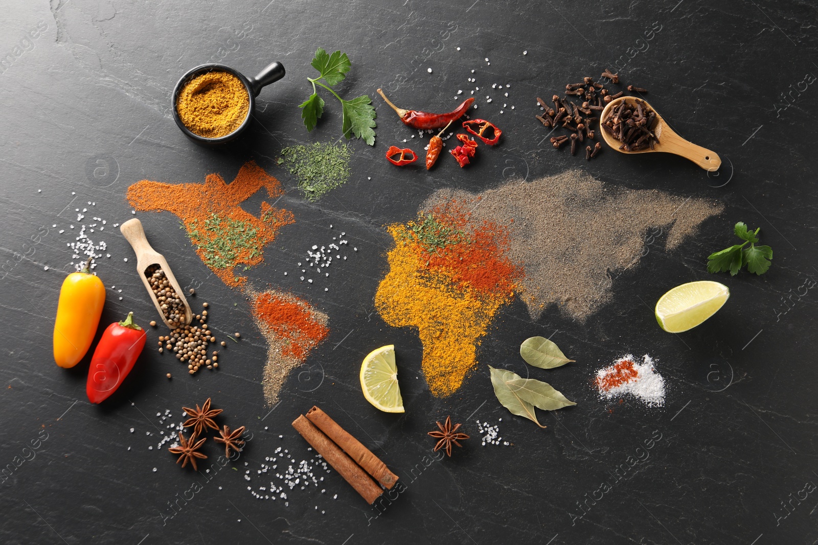 Photo of World map of different spices and products on dark textured table, flat lay