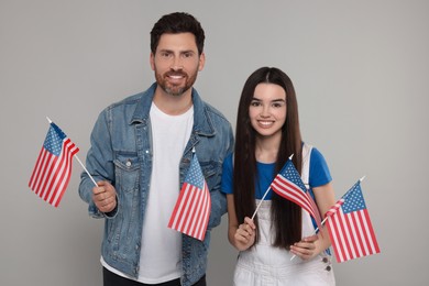 Photo of 4th of July - Independence Day of USA. Happy father and his daughter with American flags on light grey background