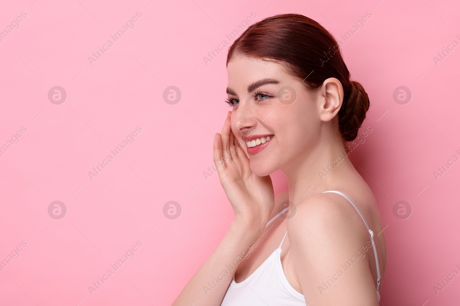 Photo of Portrait of smiling woman on pink background. Space for text