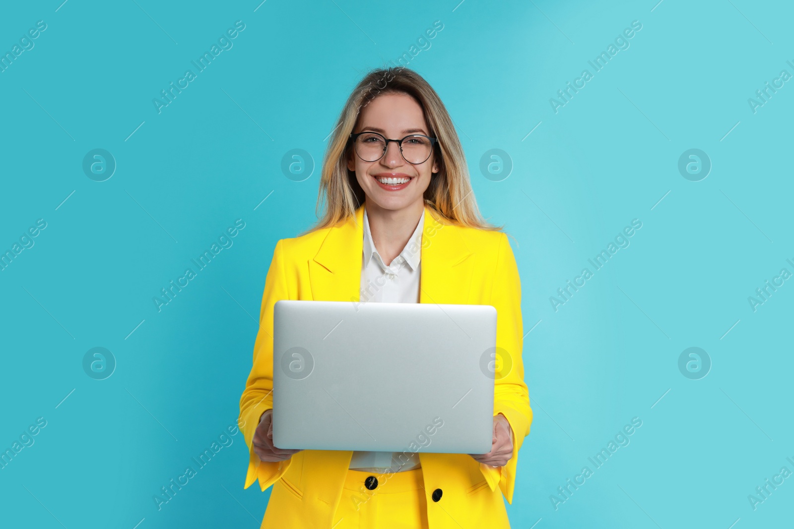 Photo of Young woman with modern laptop on light blue background