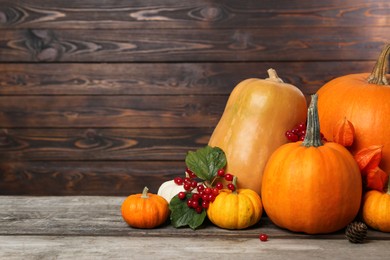 Photo of Happy Thanksgiving day. Composition with pumpkins and berries on wooden table. Space for text