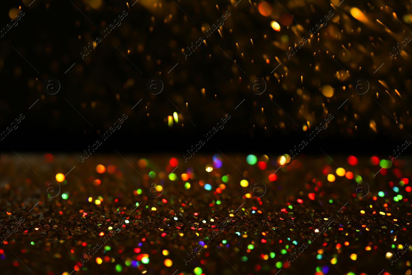 Photo of Many golden paillettes against black background. Space for text