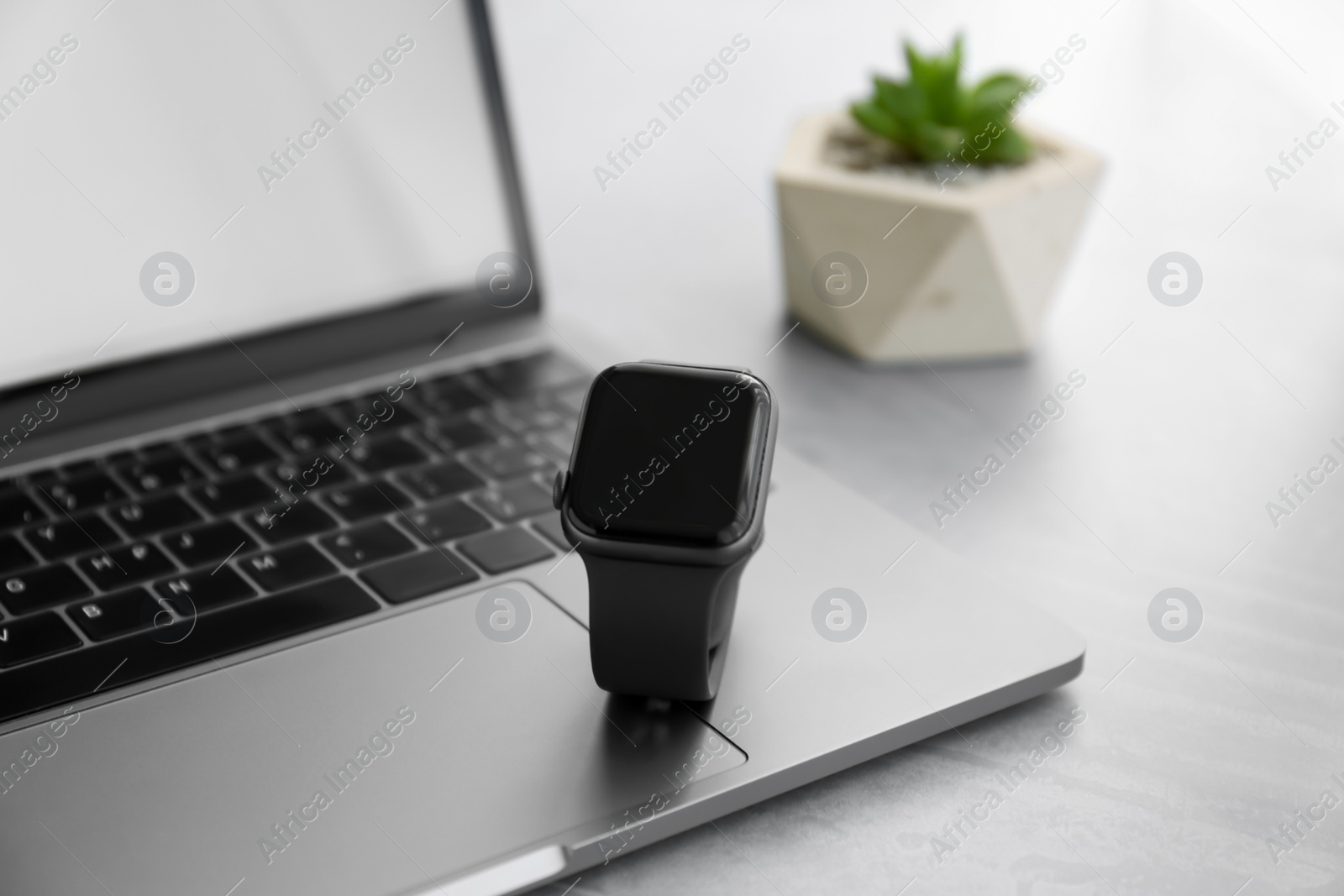 Stylish smart watch and laptop on grey table, closeup Photo of Stylish smart watch and laptop on grey table, closeup