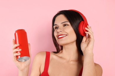 Photo of Beautiful young woman holding tin can with beverage on pink background