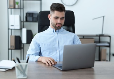 Young programmer working with laptop in office