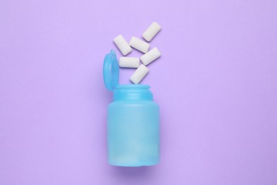 Photo of Jar with chewing gums on lilac background, flat lay