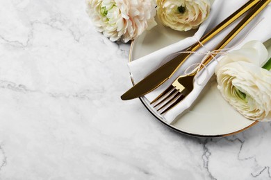 Photo of Stylish table setting with cutlery and flowers on white marble background, flat lay. Space for text