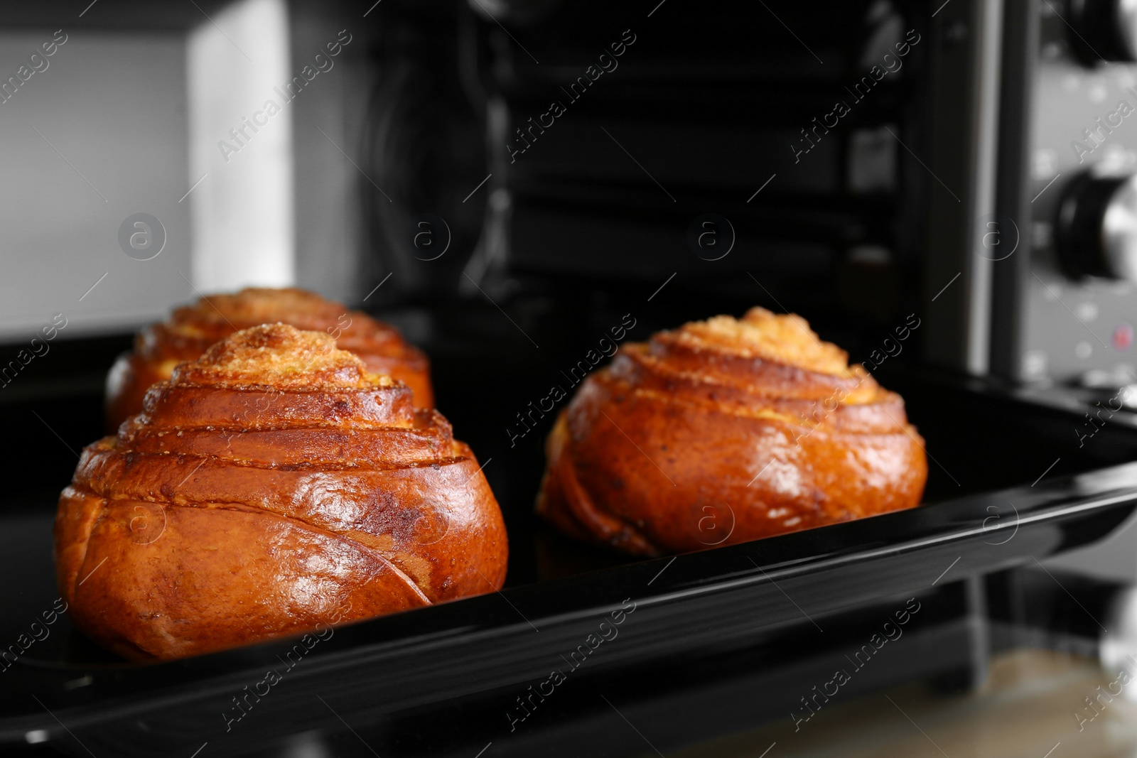 Photo of Open electric oven with delicious pastry, closeup