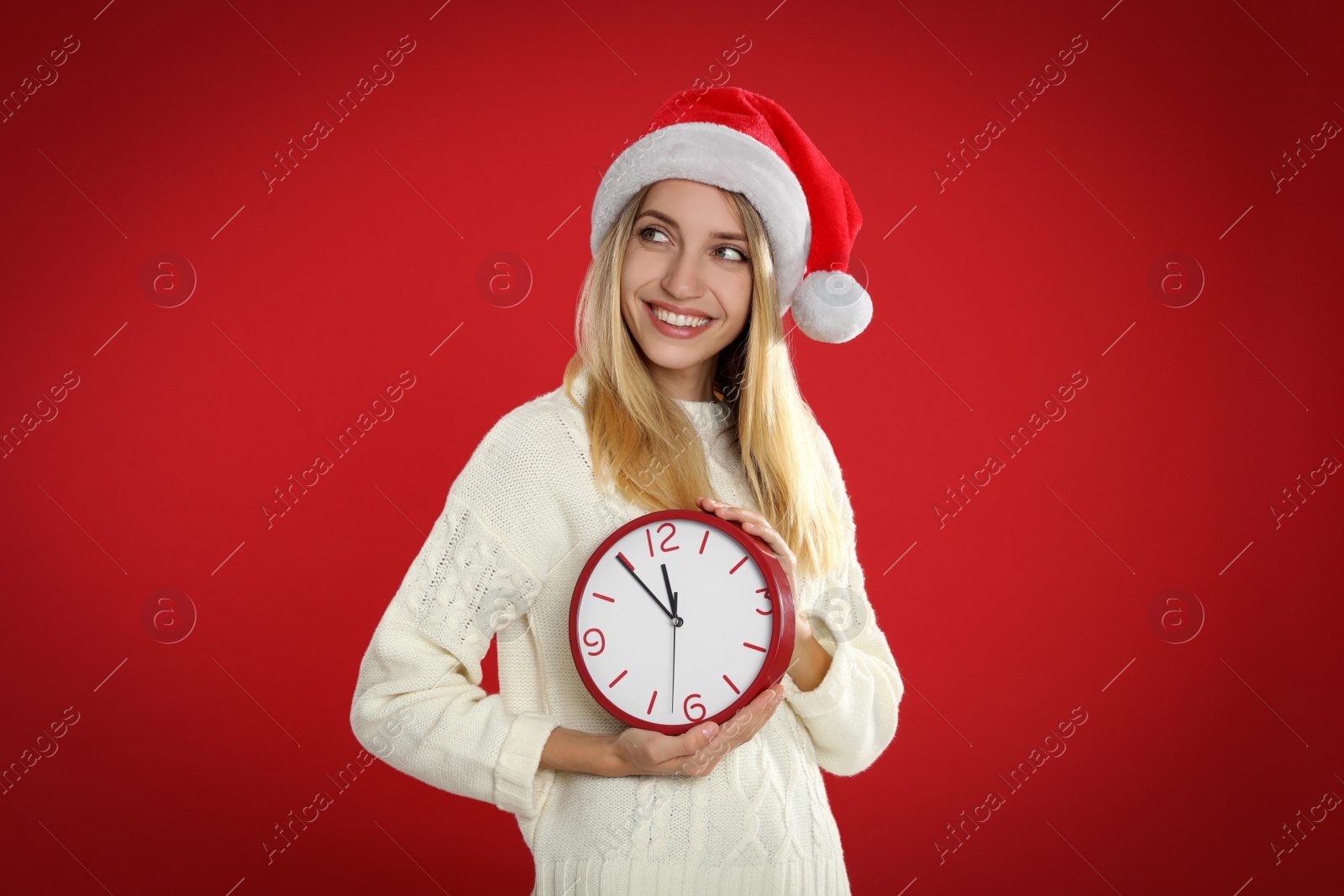 Photo of Woman in Santa hat with clock on red background. New Year countdown