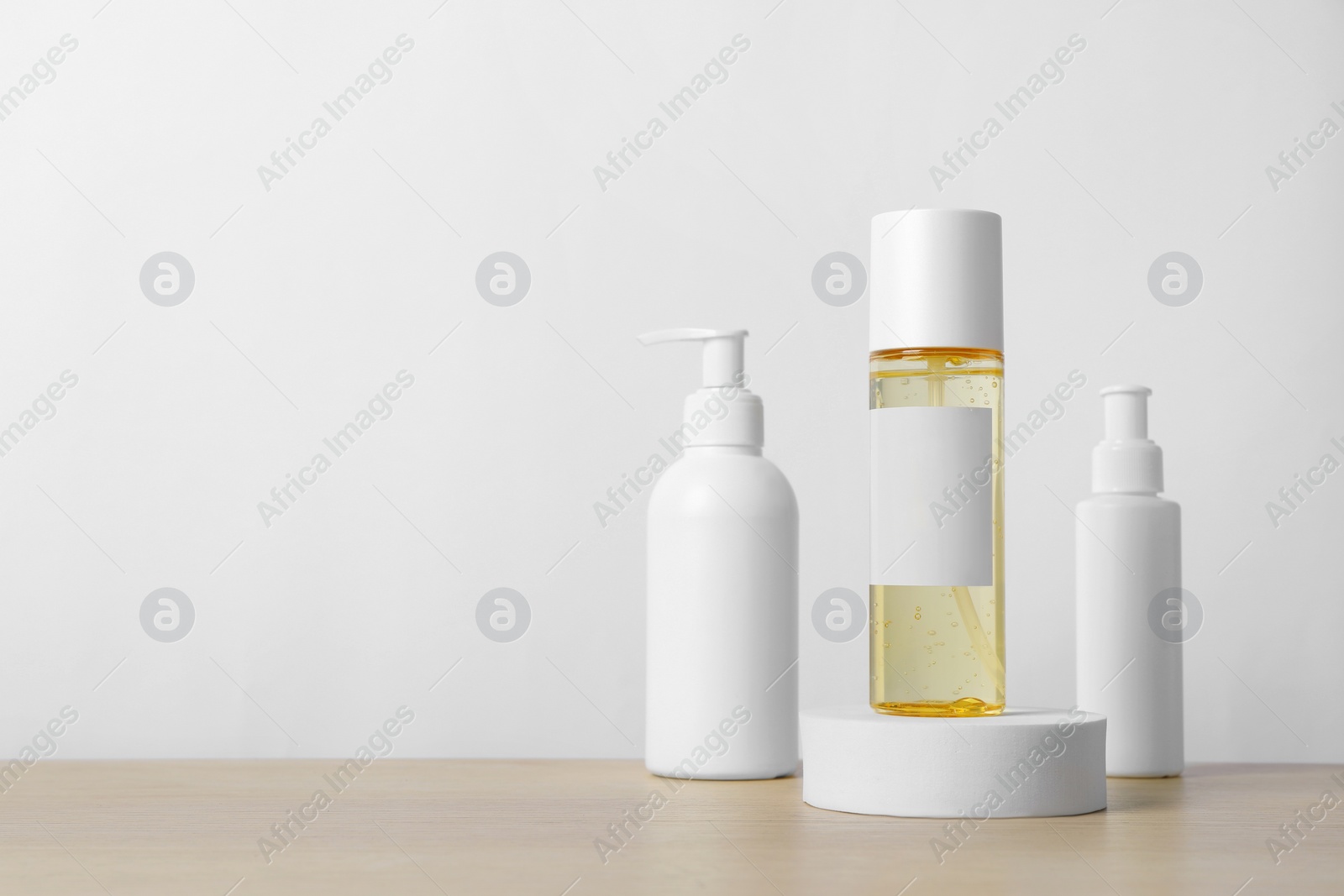 Photo of Bottles of cosmetic products on wooden table. Space for text