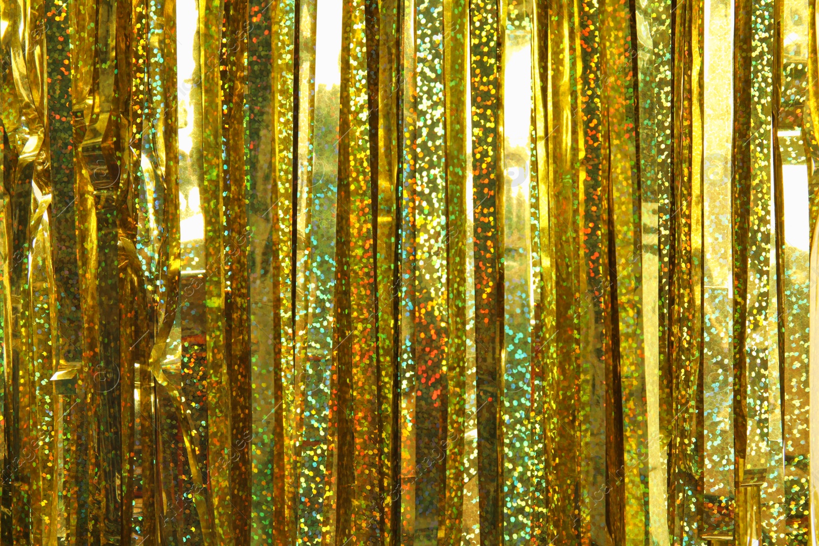 Photo of Shiny golden tinsel as background, closeup. Christmas decoration