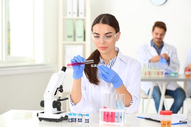 Photo of Female scientist working at table in laboratory. Research and analysis