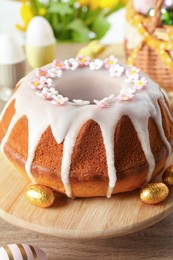 Photo of Delicious Easter cake decorated with sprinkles on wooden table