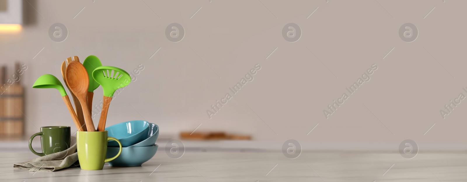 Photo of Set of different cooking utensils and ceramic dishes on white table in kitchen, space for text. Banner design