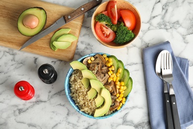 Photo of Cooked quinoa with garnish in bowl and ingredients on table, flat lay