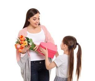 Happy woman receiving flowers and gift from her daughter on white background. Mother's day celebration