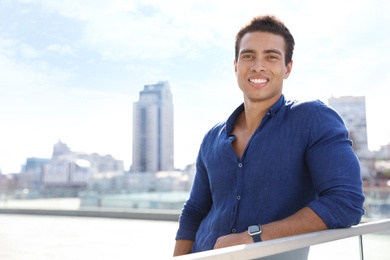 Portrait of handsome young African-American man on city street. Space for text