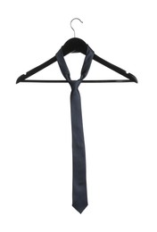 Photo of Hanger with dark necktie isolated on white