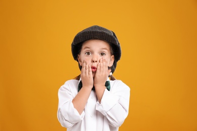 Photo of Cute little detective in hat on yellow background