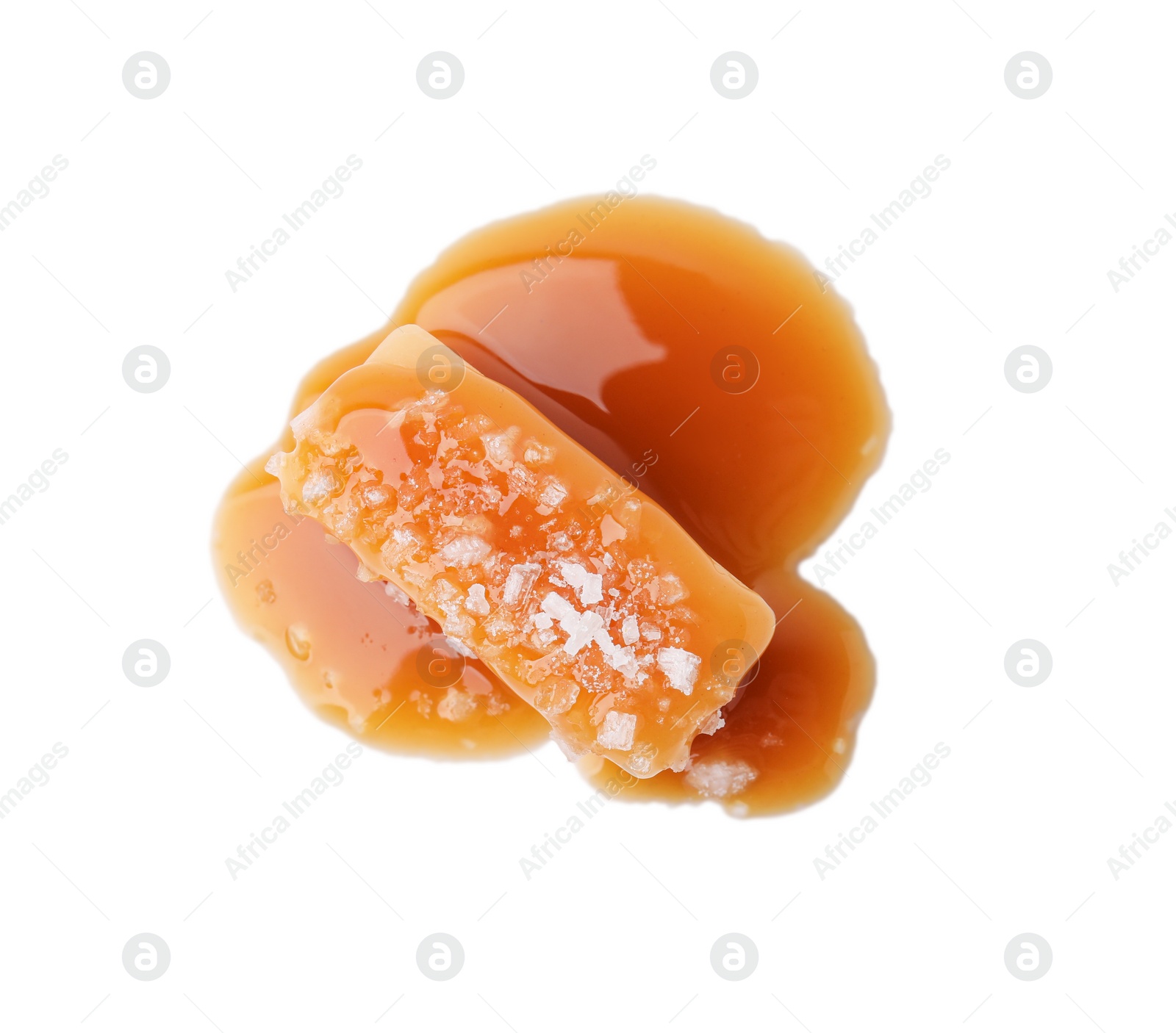 Photo of Yummy caramel candy and sea salt isolated on white, top view