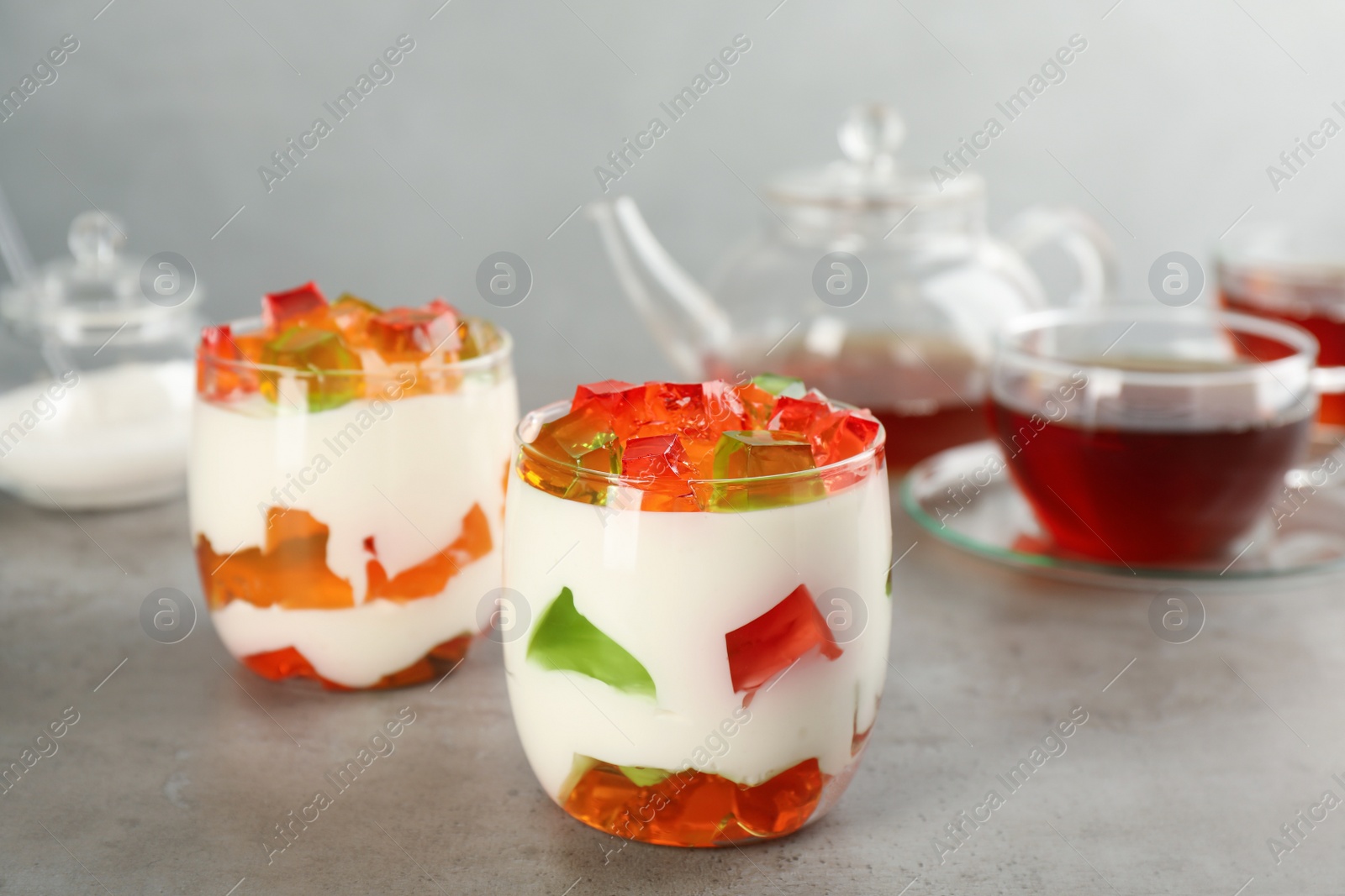 Photo of Delicious broken glass jelly dessert on grey table