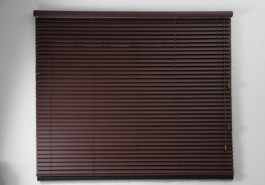 Stylish horizontal window blinds on white wall