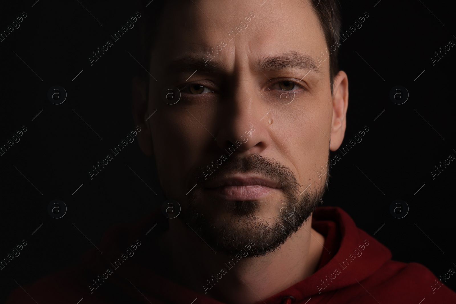 Photo of Portrait of sad man on black background